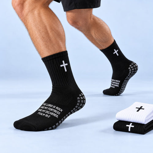 Faith Grip Socken in Schwarz getragen – weißes Kreuz, Psalm-18:2-Schrift und graue Grip-Noppen